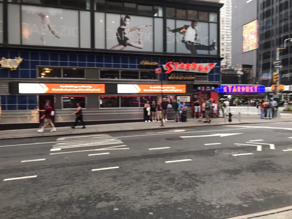 ニューヨークの街中 タイムズスクエア近くの通りとレストラン前に並ぶ人々の様子